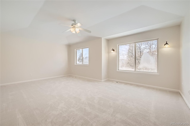 spare room with light carpet, ceiling fan, and baseboards