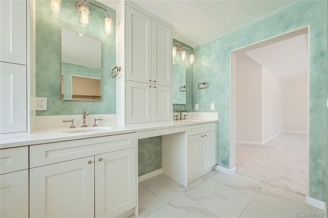 full bathroom with double vanity, marble finish floor, baseboards, and a sink