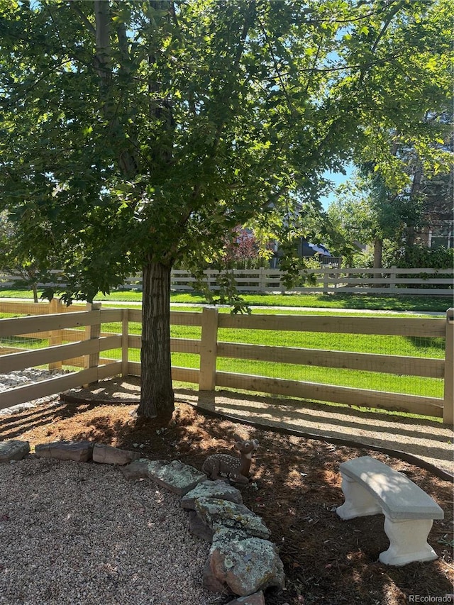 view of home's community with fence and a yard