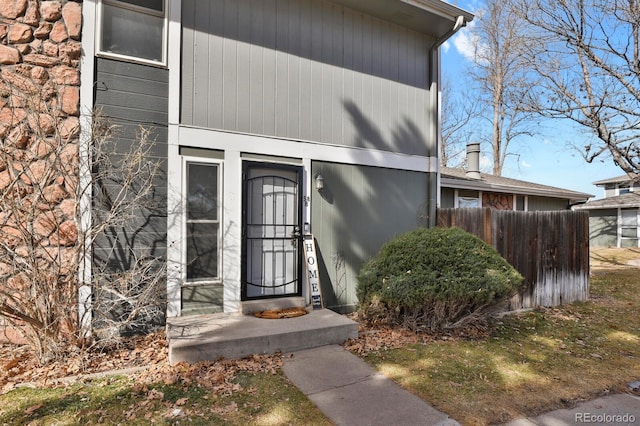 view of exterior entry featuring fence