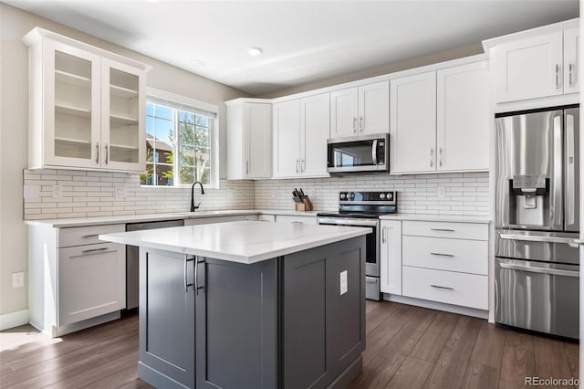 1632 Saddlesmith Pl, Castle Pines, CO 80108 - kitchen featuring appliances with stainless steel finishes, dark wood finished floors, glass insert cabinets, and light countertops