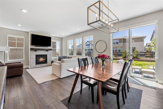1632 Saddlesmith Pl, Castle Pines, CO 80108 - dining area with a fireplace, wood finished floors, a chandelier, recessed lighting, and baseboards