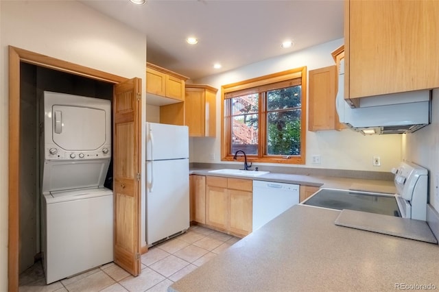 kitchen featuring white appliances, stacked washer and dryer, light brown cabinetry, a sink, and recessed lighting