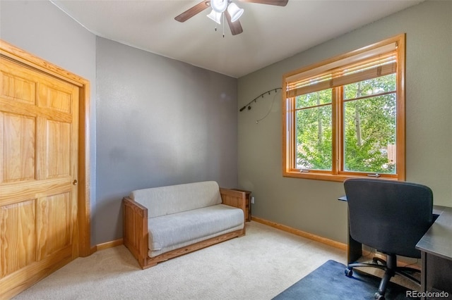 carpeted office with a ceiling fan and baseboards