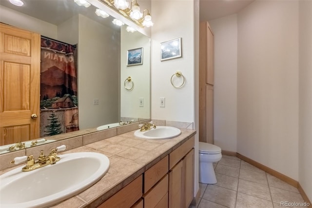 bathroom with baseboards, a sink, toilet, and tile patterned floors