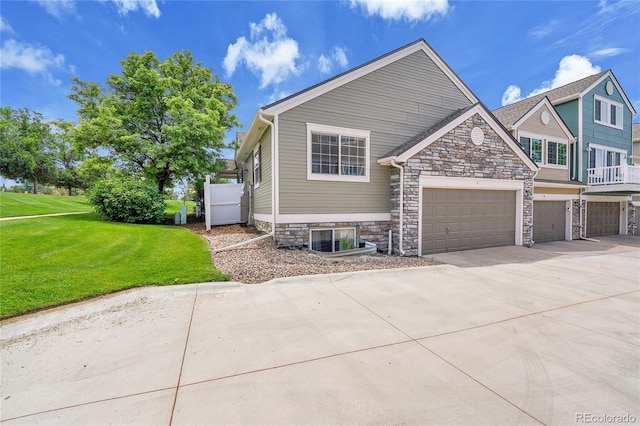 11268 Grove St Unit I, Westminster, CO 80031 - view of front of home with concrete driveway, stone siding, and a front lawn
