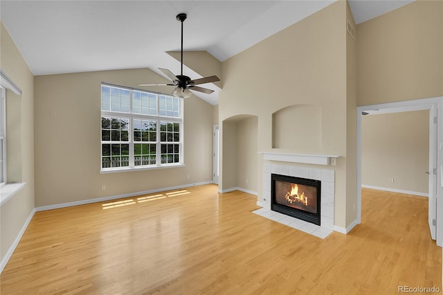 11268 Grove St Unit I, Westminster, CO 80031 - unfurnished living room with ceiling fan, a tiled fireplace, wood finished floors, and high vaulted ceiling