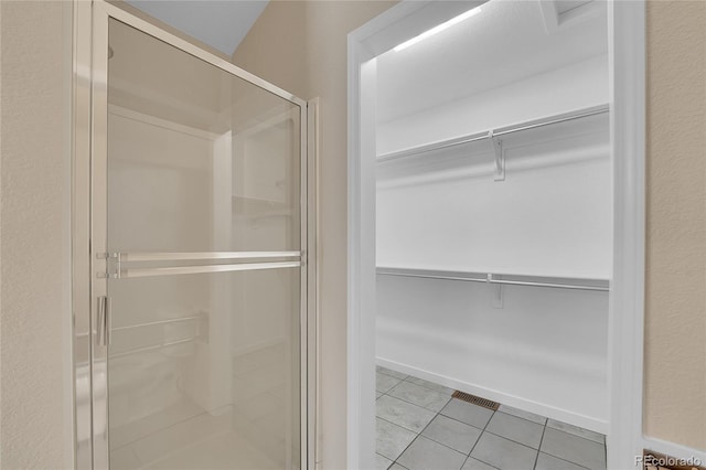 11268 Grove St Unit I, Westminster, CO 80031 - bathroom with a spacious closet, a stall shower, and tile patterned flooring