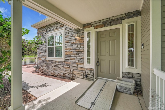 11268 Grove St Unit I, Westminster, CO 80031 - view of exterior entry featuring stone siding and a porch