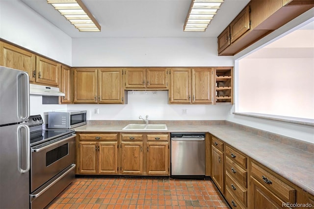 kitchen featuring stainless steel appliances, dark tile patterned floors, and sink