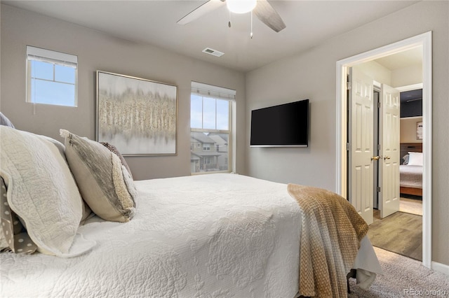 carpeted bedroom with ceiling fan and multiple windows