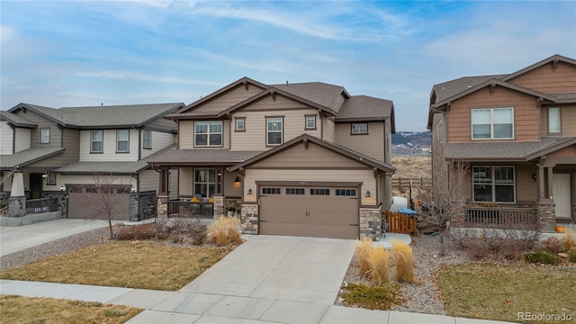 craftsman-style home with a porch, stone siding, driveway, and a garage