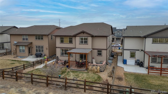 rear view of property featuring a patio area, a fenced backyard, and a shingled roof