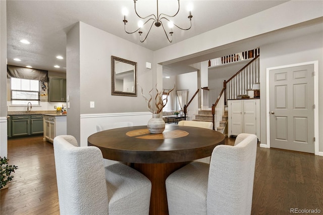 dining area featuring dark wood-type flooring, recessed lighting, a notable chandelier, and stairway