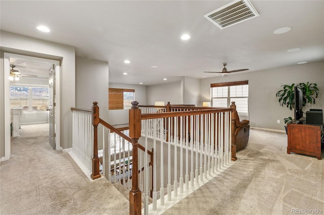 hall with carpet floors, plenty of natural light, and visible vents