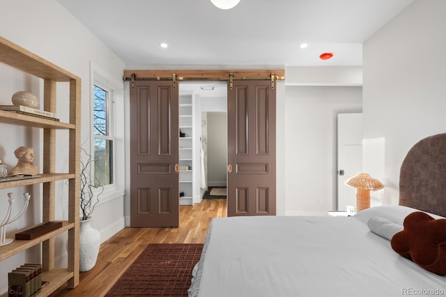 bedroom featuring light hardwood / wood-style floors and a barn door