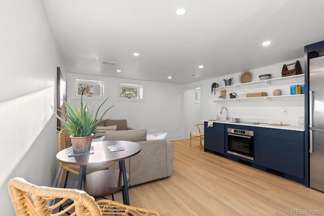 living room featuring visible vents, indoor wet bar, light wood-style flooring, and recessed lighting