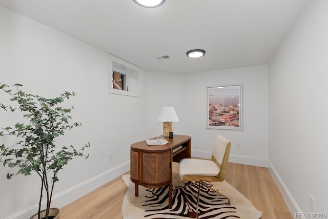 home office with baseboards, visible vents, and light wood-style floors