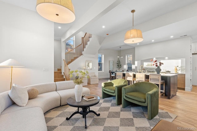 living area with light wood finished floors, stairway, and recessed lighting