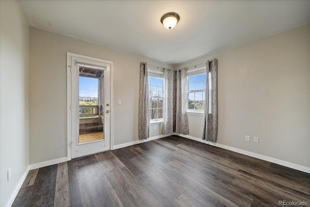 spare room with dark wood-style floors and baseboards