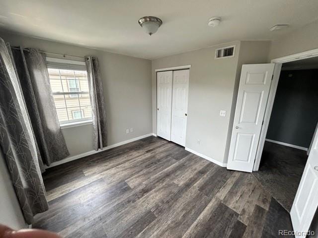 12931 Ironstone Way Unit 303, Parker, CO 80134 - unfurnished bedroom with dark wood-type flooring, a closet, and baseboards