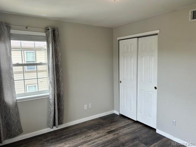 12931 Ironstone Way Unit 303, Parker, CO 80134 - unfurnished bedroom with dark wood-type flooring, a closet, and baseboards