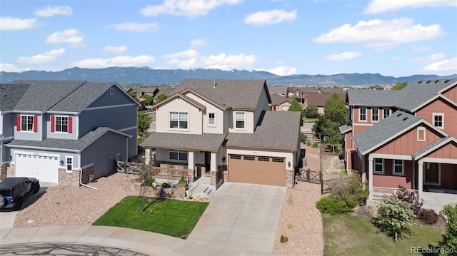 6612 Big Leaf Ln, Colorado Springs, CO 80927 - craftsman-style home with a residential view, concrete driveway, a mountain view, covered porch, and stone siding