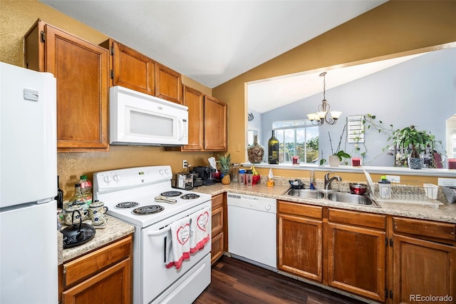 kitchen featuring lofted ceiling, sink, white appliances, decorative light fixtures, and dark hardwood / wood-style flooring