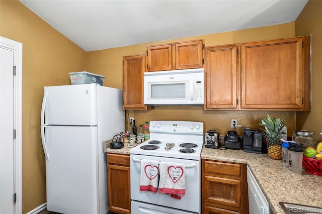 kitchen with white appliances and vaulted ceiling