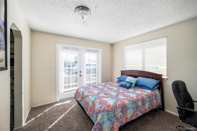 carpeted bedroom featuring access to outside, a textured ceiling, and french doors