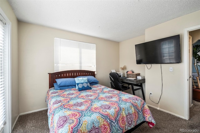 bedroom with dark colored carpet and a textured ceiling