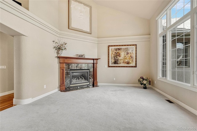 unfurnished living room featuring high vaulted ceiling, carpet, and a fireplace