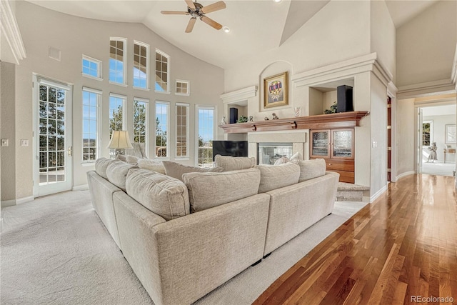 living room featuring high vaulted ceiling, light hardwood / wood-style flooring, and ceiling fan