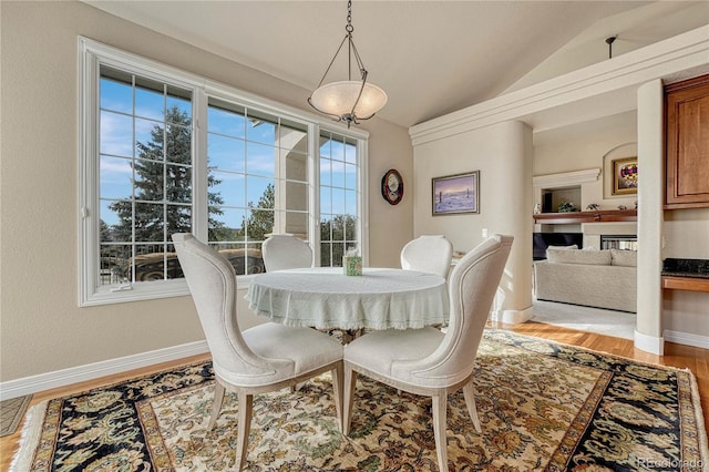 dining room featuring light hardwood / wood-style floors and vaulted ceiling