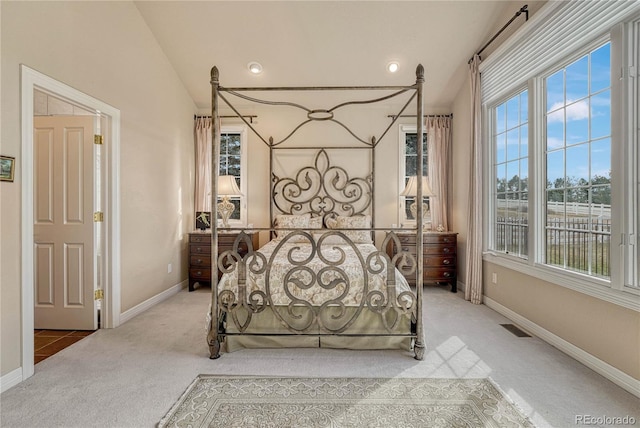 bedroom featuring multiple windows, lofted ceiling, and carpet floors