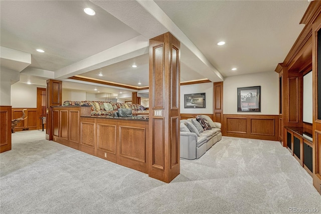 interior space featuring decorative columns, a textured ceiling, and light colored carpet