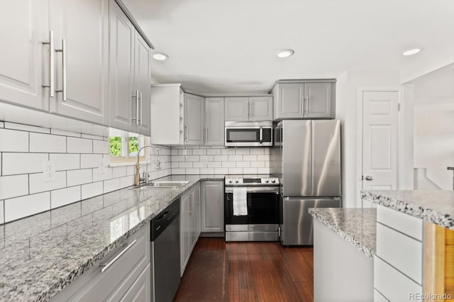 4381 Dixon Dr, Westminster, CO 80031 - kitchen featuring appliances with stainless steel finishes, a sink, gray cabinetry, light stone countertops, and recessed lighting