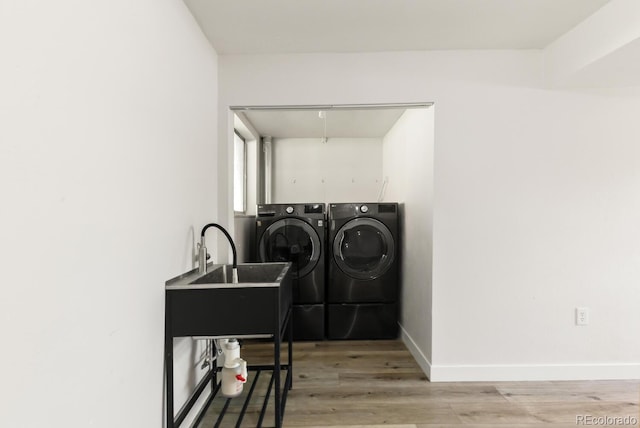 4381 Dixon Dr, Westminster, CO 80031 - laundry area featuring washing machine and dryer, light wood-style flooring, and baseboards