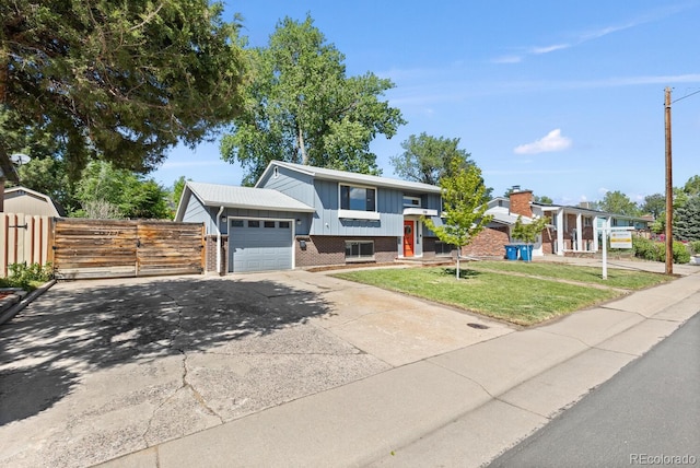 4381 Dixon Dr, Westminster, CO 80031 - view of front of home with brick siding, an attached garage, board and batten siding, concrete driveway, and a gate