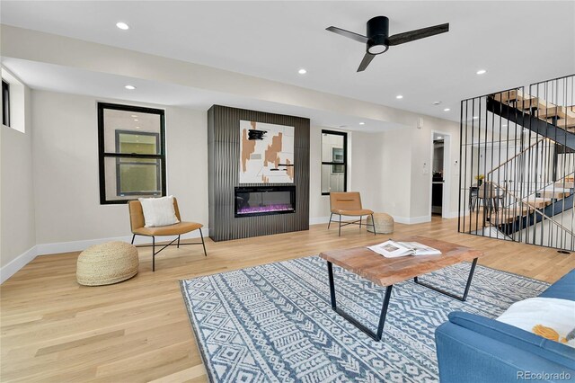 2162 S Ash St, Denver, CO 80222 - living area featuring a glass covered fireplace, stairs, light wood-style flooring, baseboards, and recessed lighting