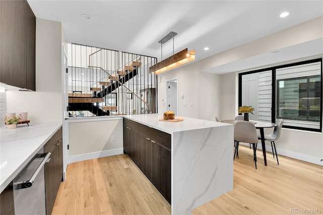 2162 S Ash St, Denver, CO 80222 - kitchen featuring modern cabinets, dark brown cabinets, light wood-style floors, stainless steel dishwasher, and a peninsula