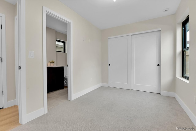2162 S Ash St, Denver, CO 80222 - unfurnished bedroom featuring light colored carpet, baseboards, and a closet