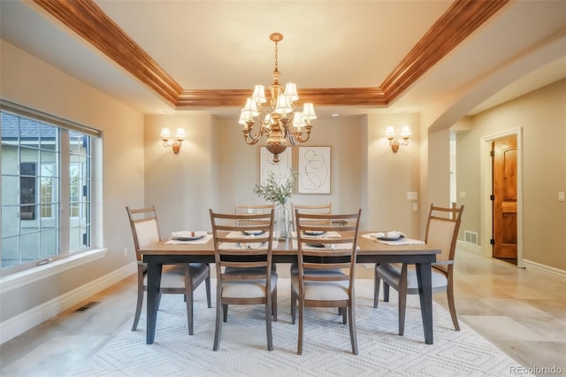 dining space with baseboards, a raised ceiling, visible vents, and crown molding