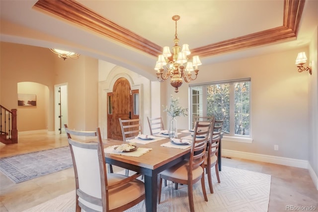 dining area with stairs, arched walkways, a raised ceiling, and ornamental molding