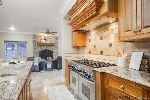 kitchen featuring crown molding, tasteful backsplash, range with two ovens, and custom range hood