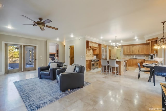 living area featuring ceiling fan with notable chandelier, recessed lighting, and crown molding