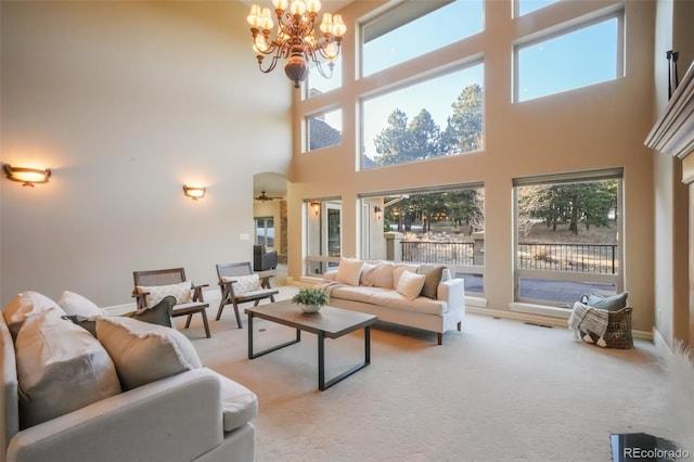 living room featuring visible vents, light colored carpet, a wealth of natural light, and an inviting chandelier