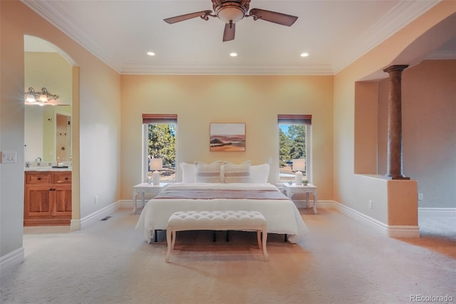 bedroom with multiple windows, arched walkways, and light colored carpet