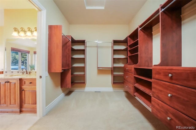 walk in closet with light colored carpet and a sink