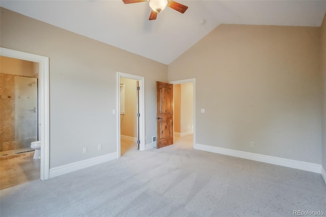 unfurnished bedroom featuring lofted ceiling, light carpet, a spacious closet, and baseboards